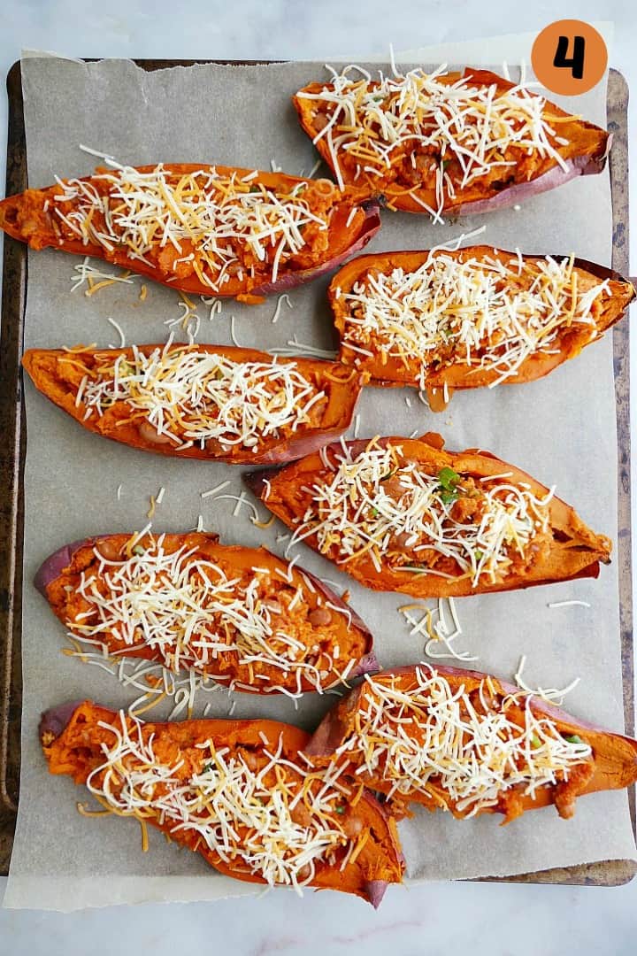 8 stuffed sweet potato jackets on a baking sheet before going into the oven