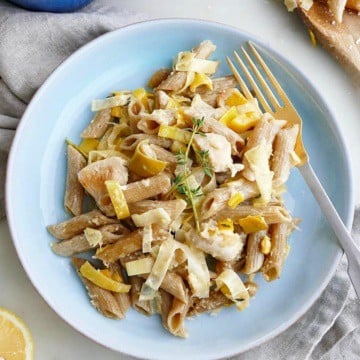 blue plate with chicken and leek pasta bake and a gold fork
