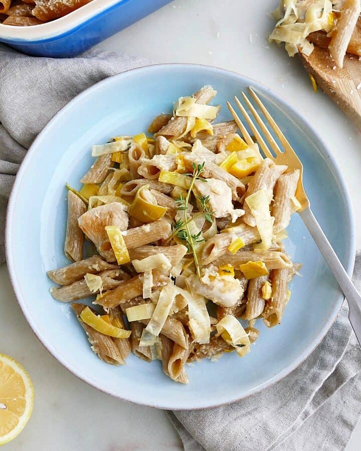 blue plate with chicken and leek pasta bake and a gold fork