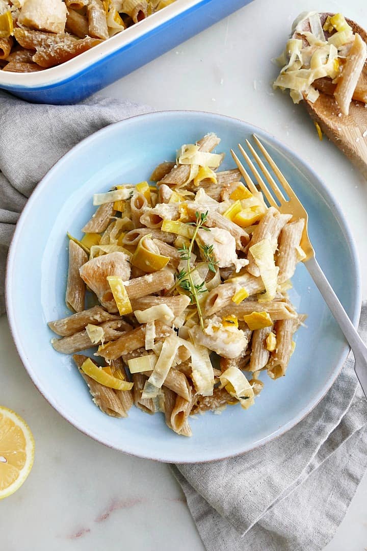 blue plate with chicken and leek pasta bake and a gold fork