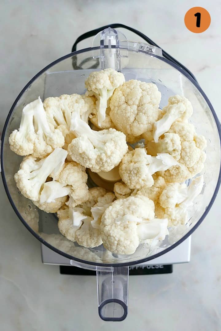 cauliflower florets in a food processor with the number 1 in the top corner