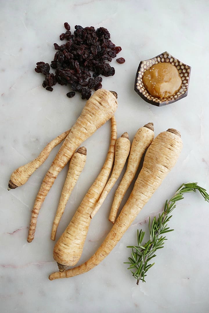 raisins, 7 parsnips, honey, and rosemary on a white counter