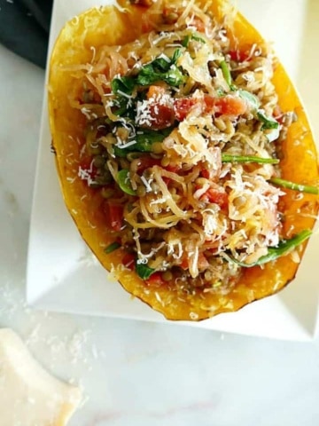 close-up of italian spaghetti squash stuffed with spinach and lentils on a plate