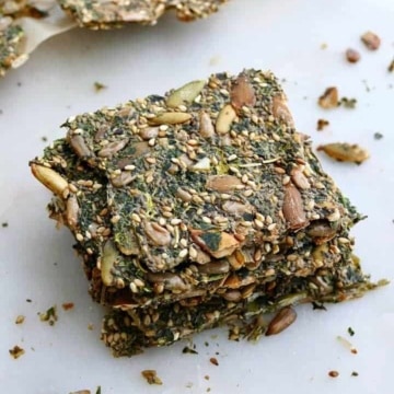 4 kale crackers stacked on top of each other on a white counter