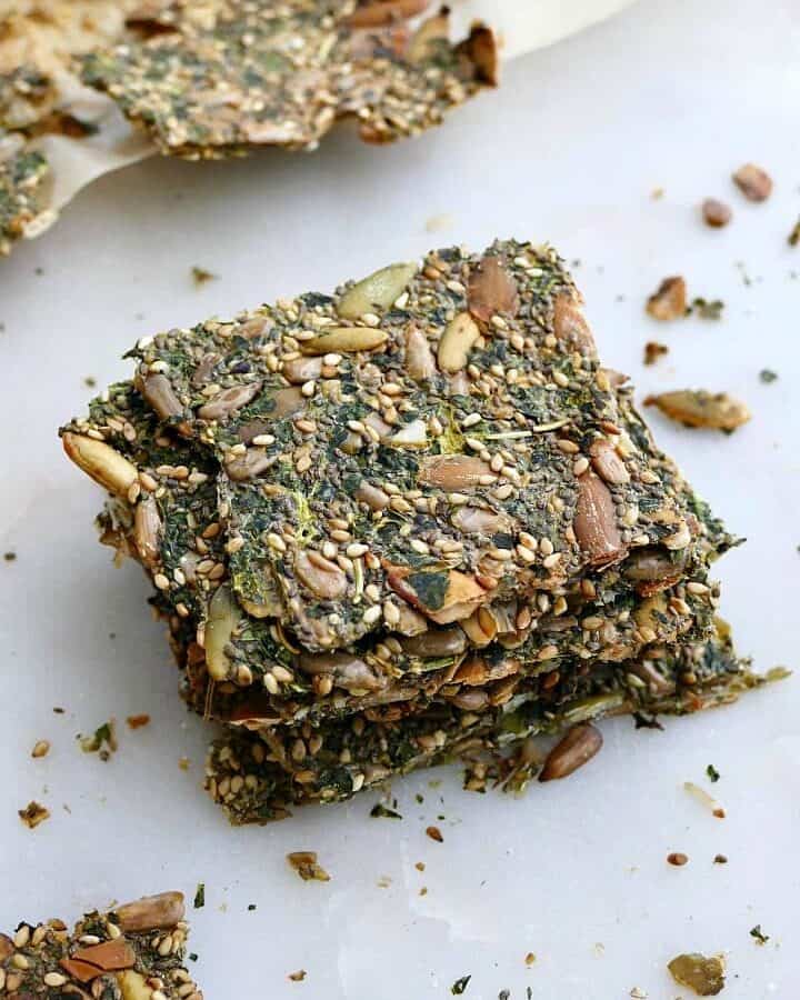 4 kale crackers stacked on top of each other on a white counter