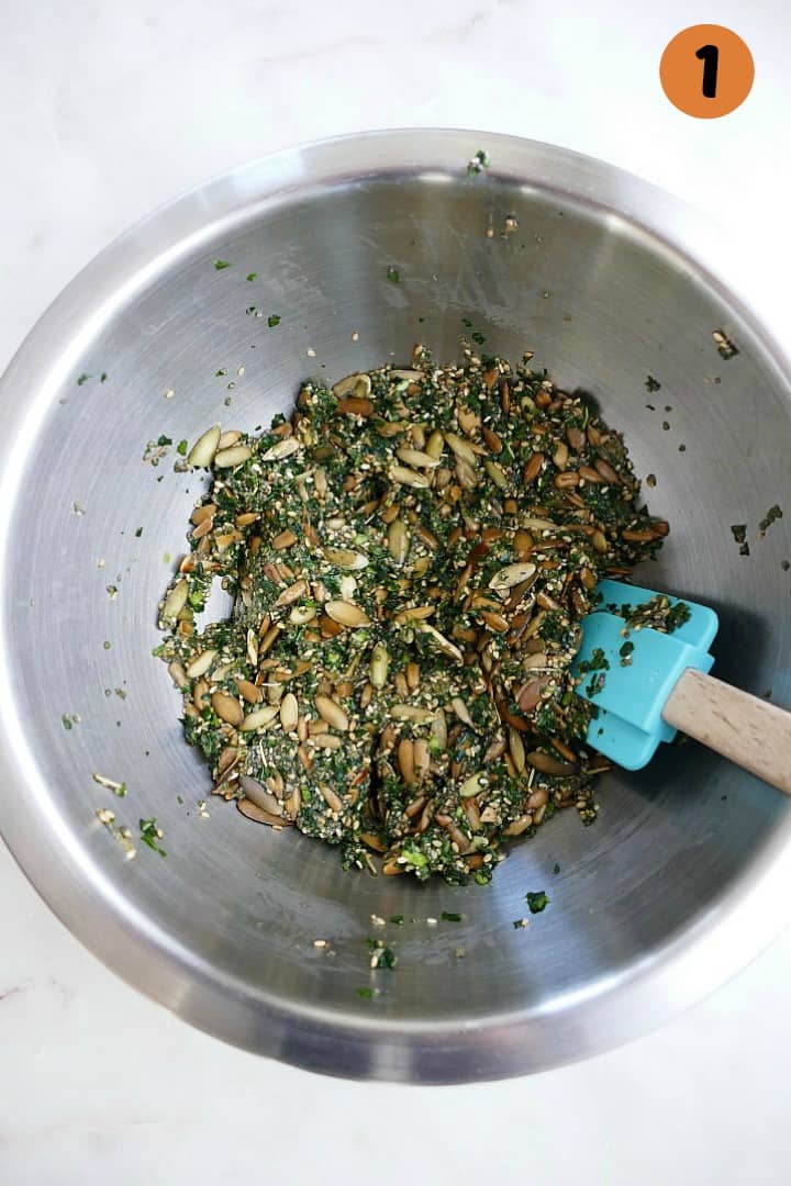 mixture for kale crackers in a silver mixing bowl with a spatula