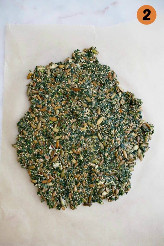 mixture for kale crackers on a piece of parchment paper on a white counter