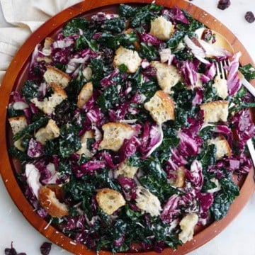 kale radicchio salad with sourdough croutons on a large wooden platter