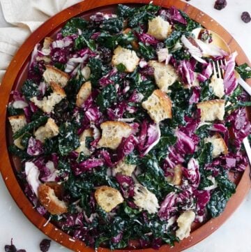 kale radicchio salad with sourdough croutons on a large wooden platter