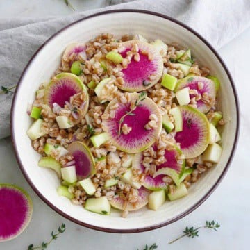 watermelon radish salad with thyme in a white bowl on a counter