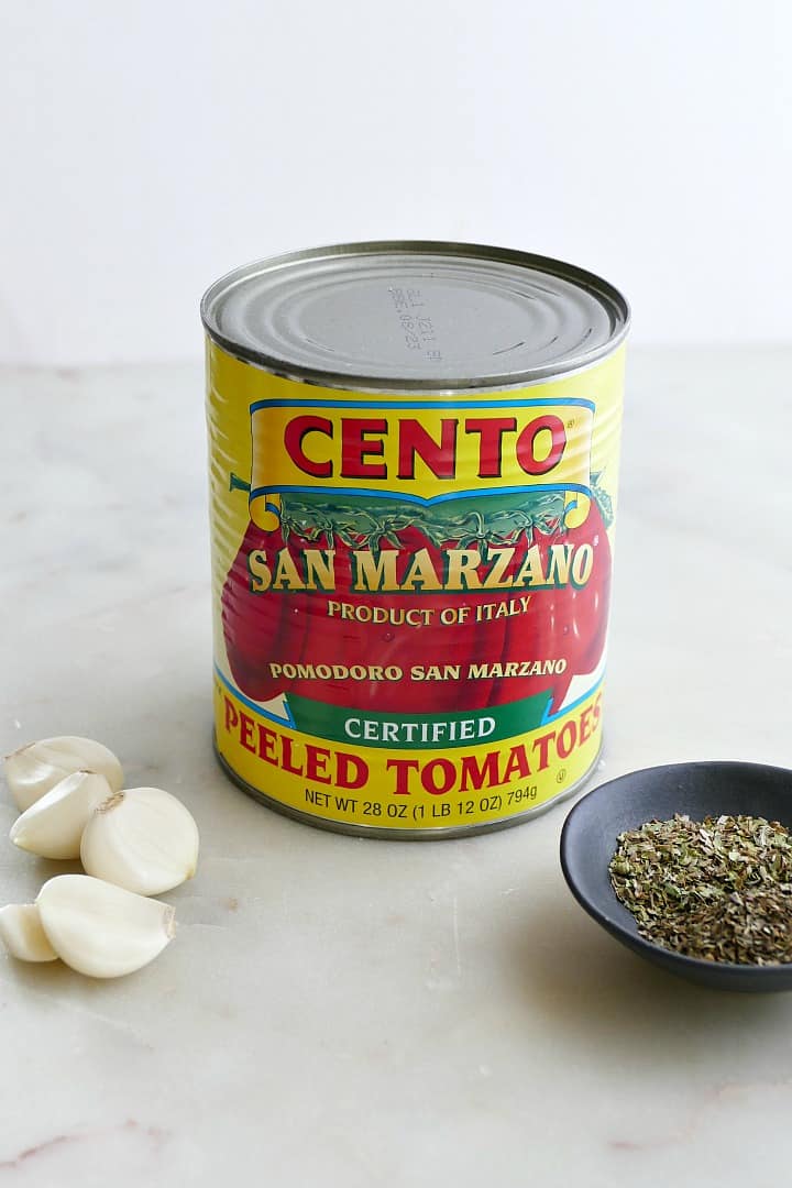 a can of cento san marzano tomatoes surrounded by garlic and herbs