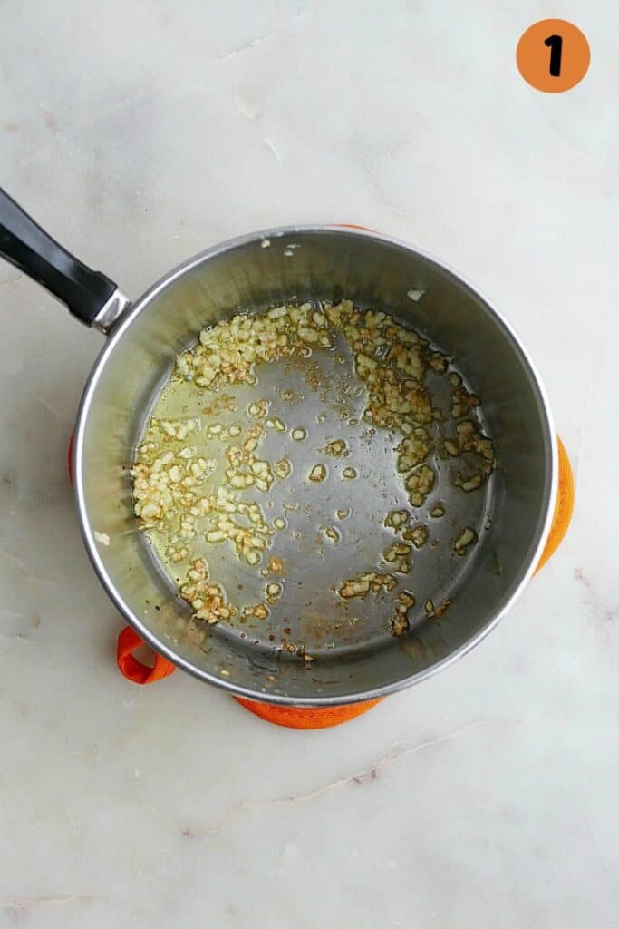 sauteed garlic in a stainless steel saucepan on a counter