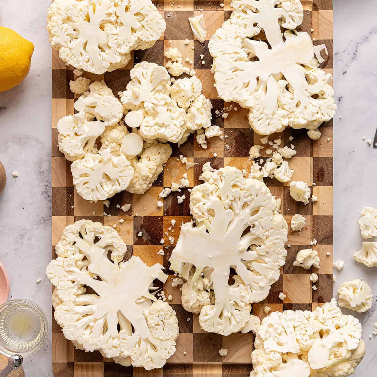 Sliced cauliflower steaks on a cutting board.