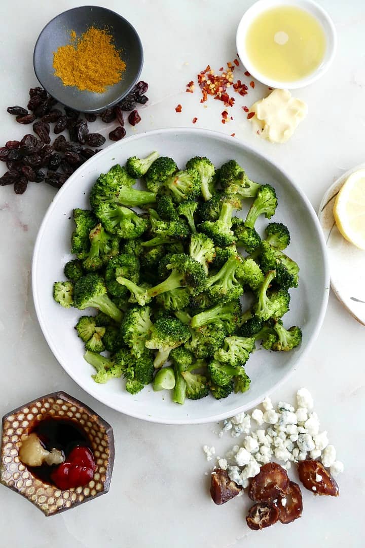 plate of the roasted frozen broccoli in the middle of five different seasoning combos