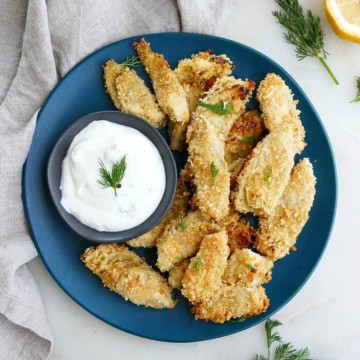 crispy artichoke hearts with aioli on a blue plate on top of a counter