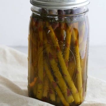 side view of pickled asparagus upright in a quart-sized glass mason jar