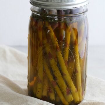side view of pickled asparagus upright in a quart-sized glass mason jar