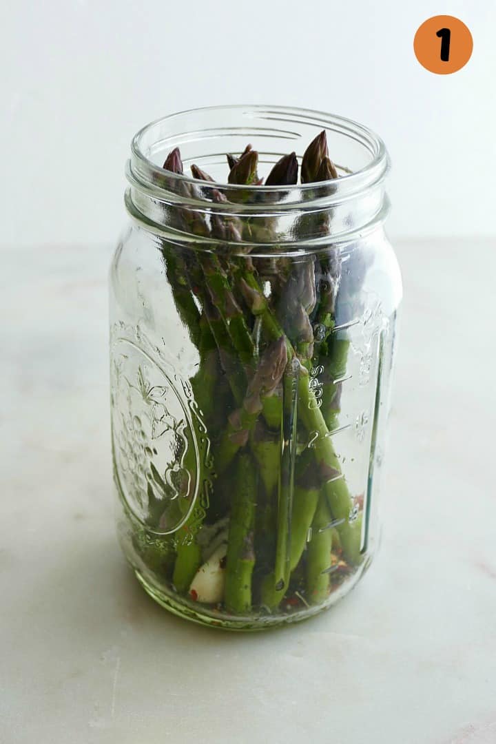 15 asparagus spears upright in a glass quart mason jar