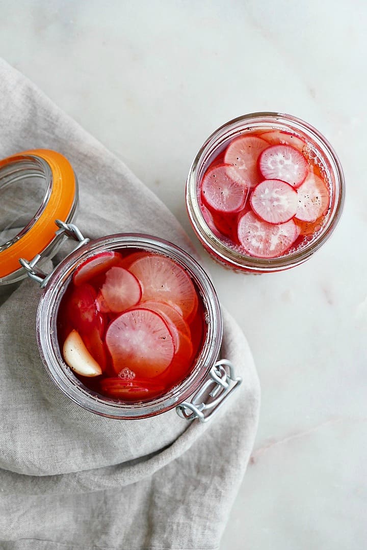 overhead view of two glass jars stuffed with pickled vegetables on a counter