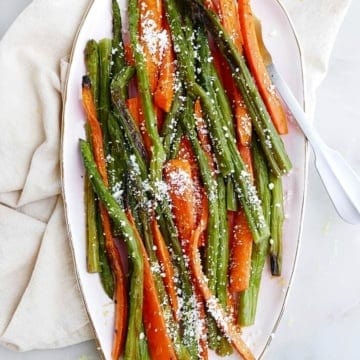 roasted asparagus and carrots on an oval tray on top of a counter