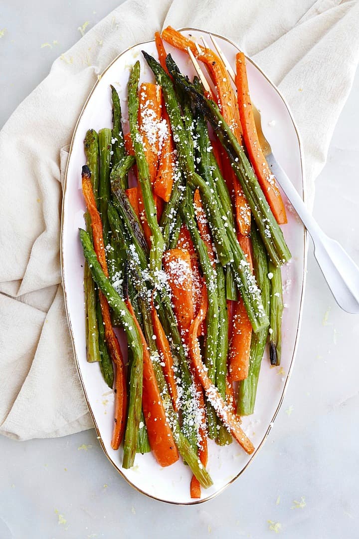 roasted asparagus and carrots on an oval tray on top of a counter
