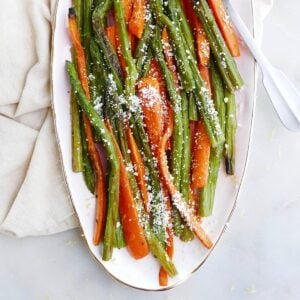 square image of roasted asparagus and carrots on a pink oval tray