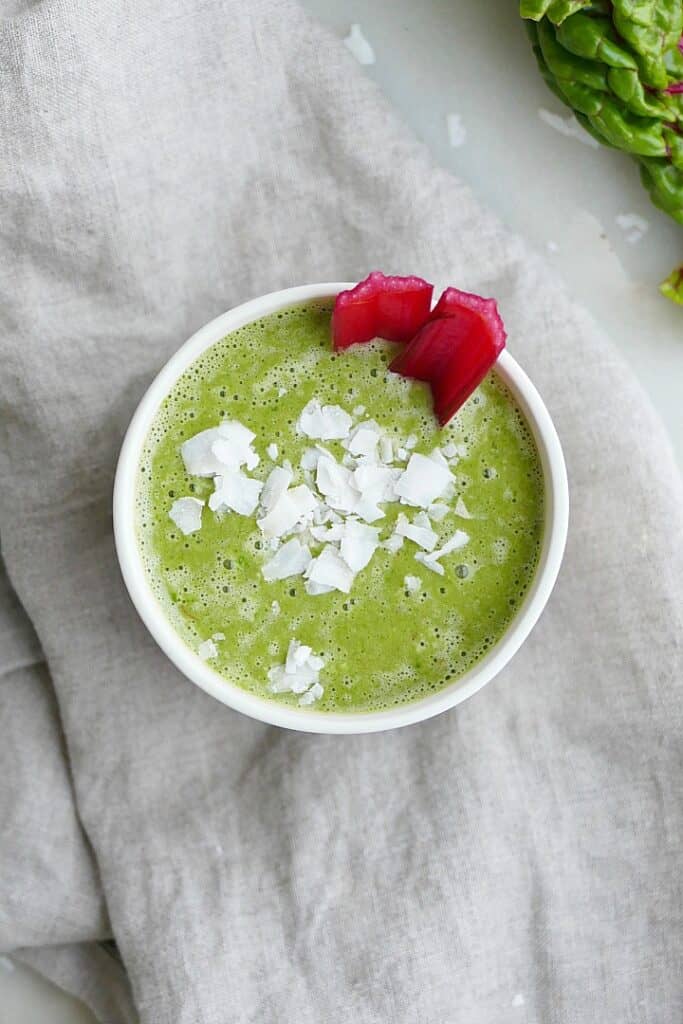 close up shot of swiss chard smoothie topped with coconut flakes