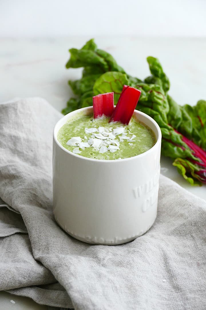 side view of finished smoothie topped with coconut and red chard stems