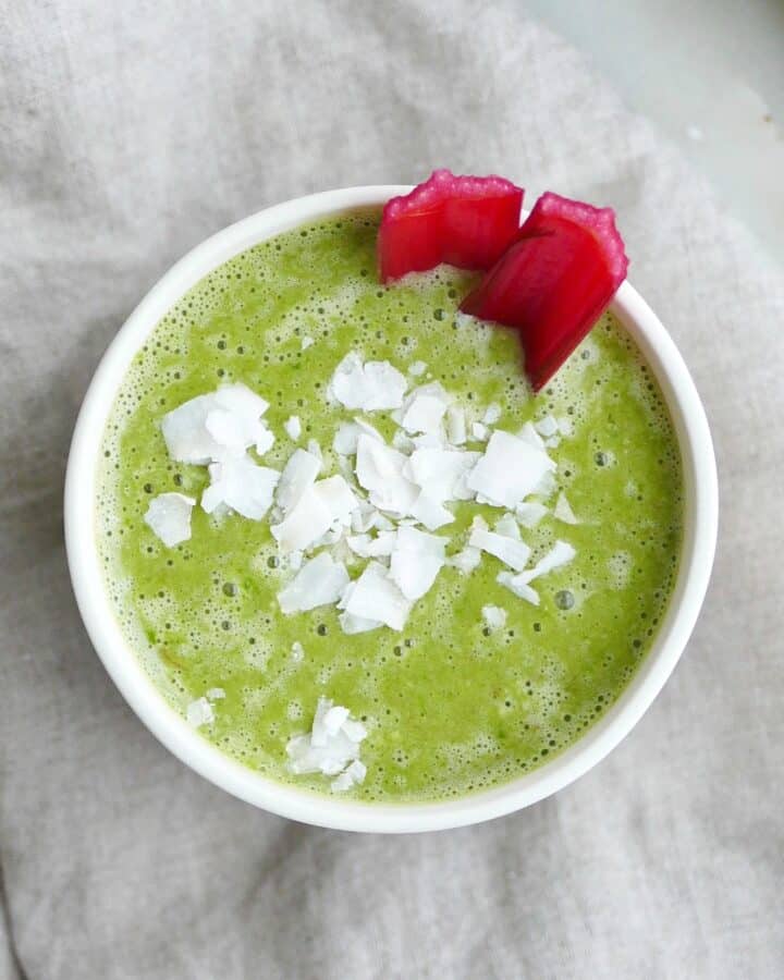 square image of swiss chard smoothie topped with coconut flakes