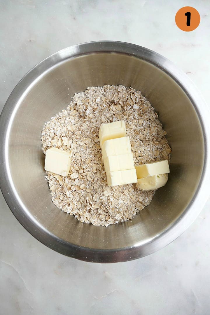 oats and slices of butter in a mixing bowl on a counter