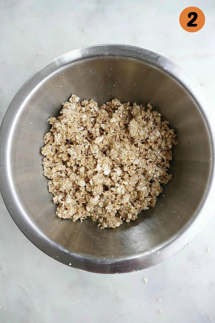 oats mixed with butter into a crumble in a mixing bowl
