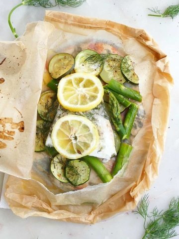square image of cod en papillote with fresh lemon slices and dill