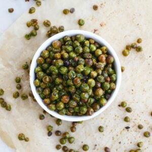 square image of roasted peas in a bowl on parchment paper