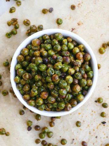 square image of roasted peas in a bowl on parchment paper
