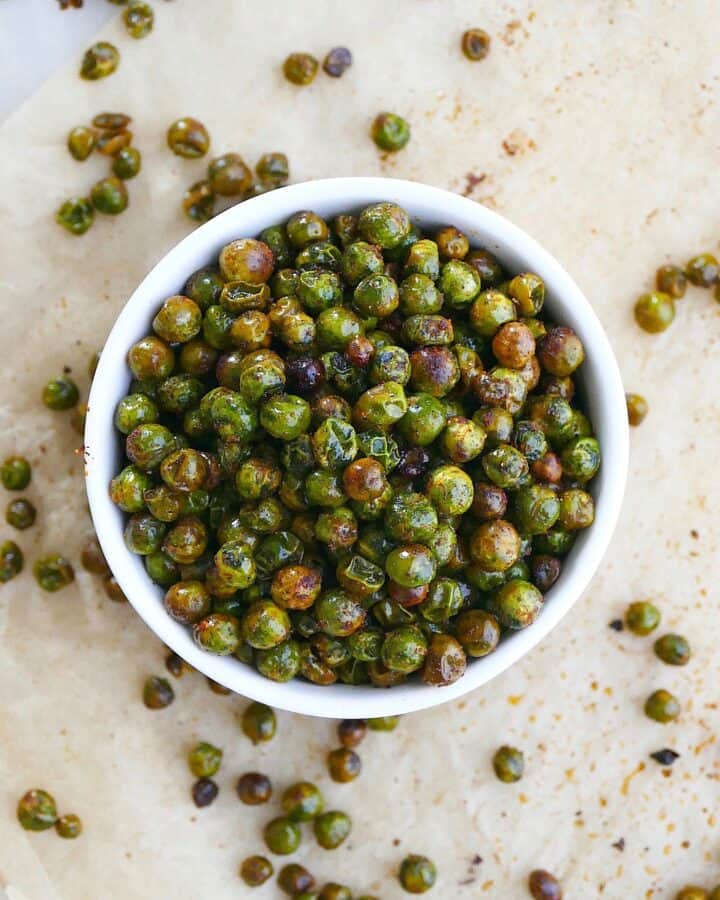 square image of roasted peas in a bowl on parchment paper