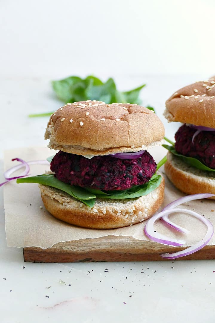 black bean beet burger on a seeded whole wheat bun with lettuce, onion, and mayo