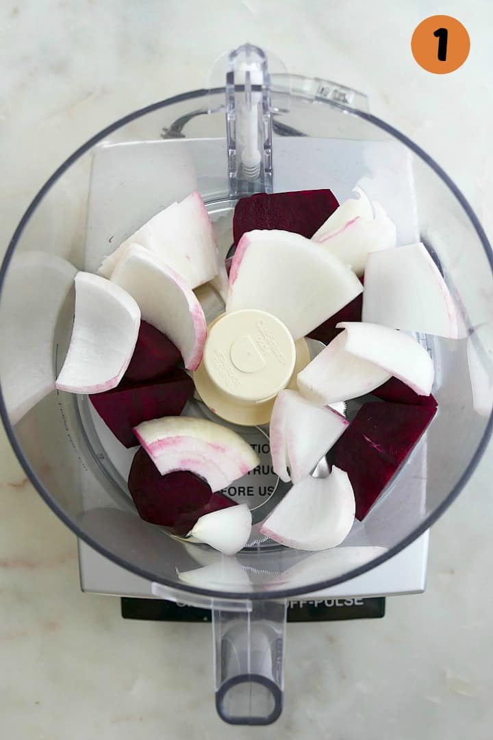 onions and beets in a food processor on a counter