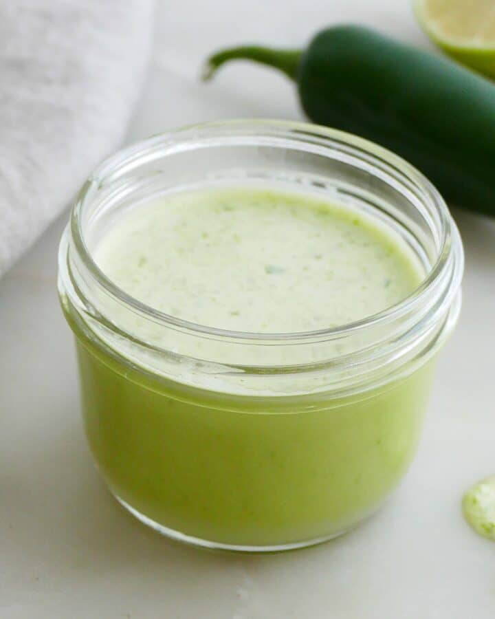 square image of jalapeno salad dressing in a small glass jar