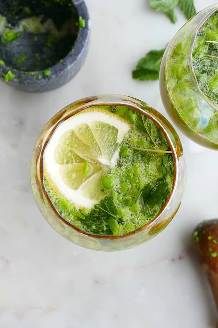 finished kombucha mocktail garnished with lemon slices and mint on a counter