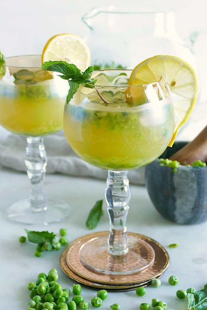 two long stem glasses with kombucha mocktails garnished with lemon slices