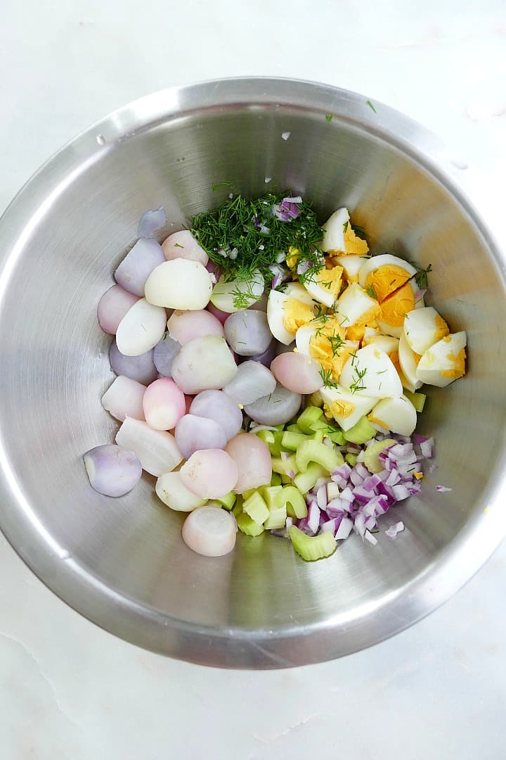 ingredients for radish potato salad in a silver mixing bowl on a counter