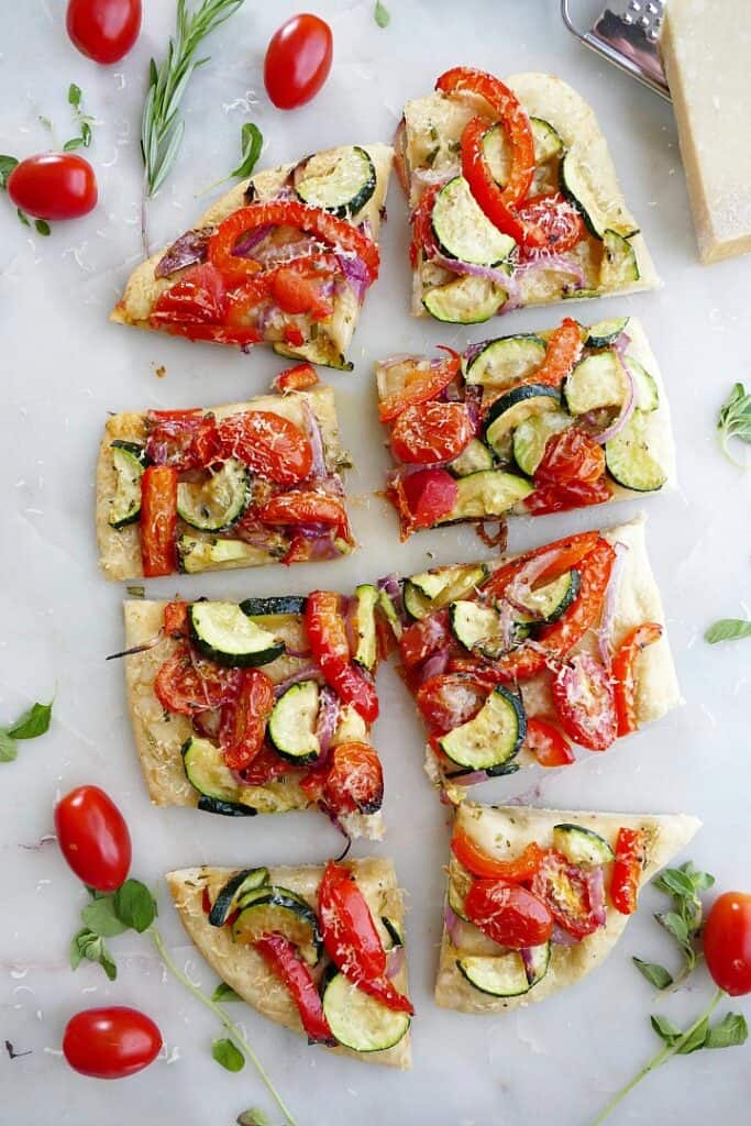 flatbread topped with tomatoes and summer veggies sliced into 8 pieces