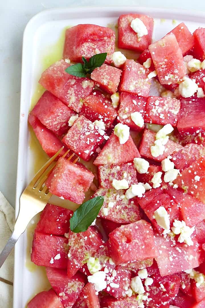 close up shot of spicy watermelon salad with feta and mint on a platter