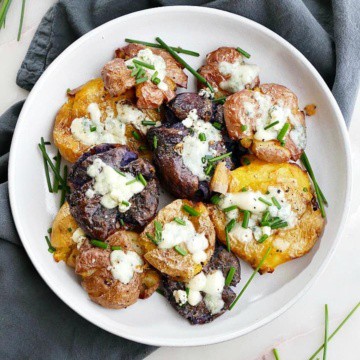 plate of crispy smashed potatoes with blue cheese and chives