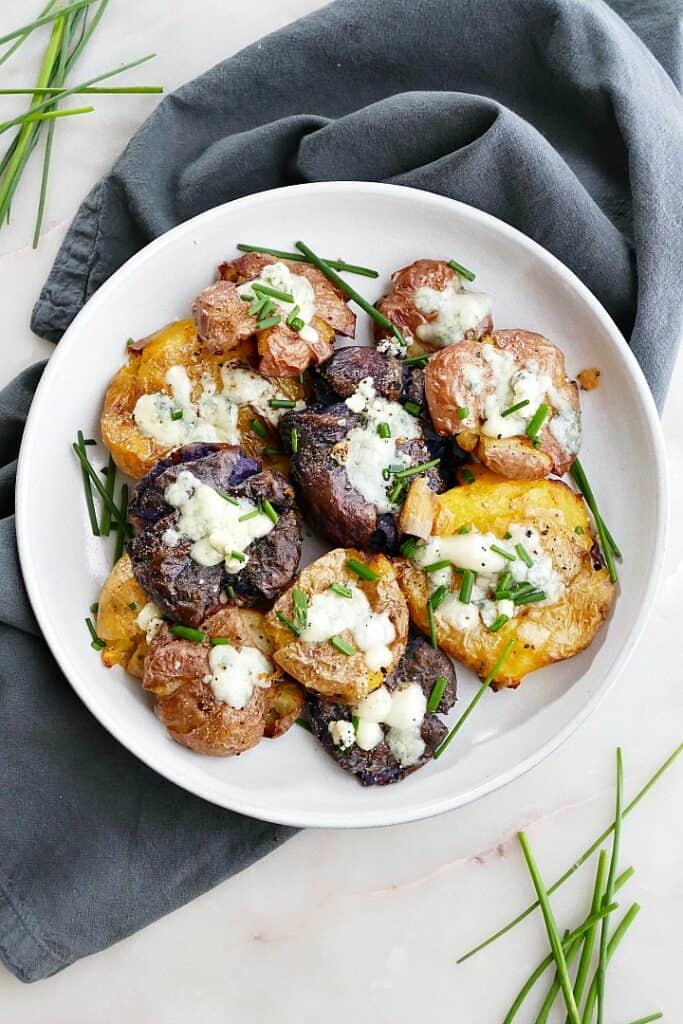 plate of crispy smashed potatoes with blue cheese and chives