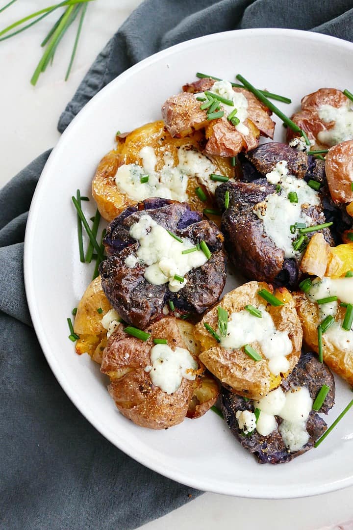 close-up shot of smashed potatoes with blue cheese and chives on a plate