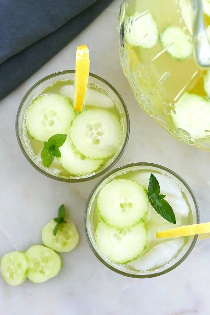 two glasses of cucumber mint lemonade garnished with cucumber slices