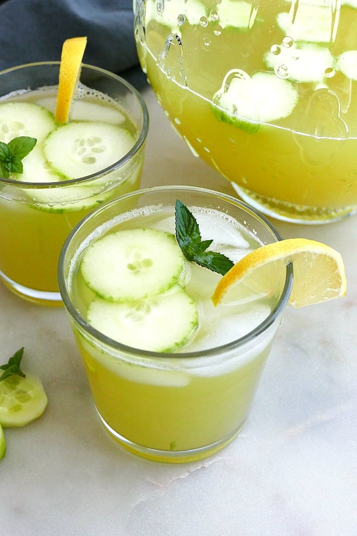 close photo of a glass of cucumber mint lemonade with garnishes