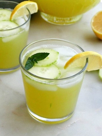 square image of glasses with lemonade and garnishes on a counter