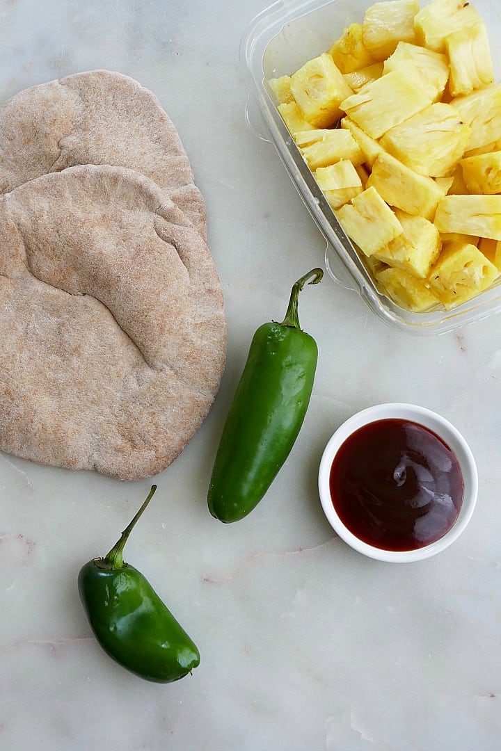 whole wheat pita, jalapenos, bbq sauce, and pineapple on a counter